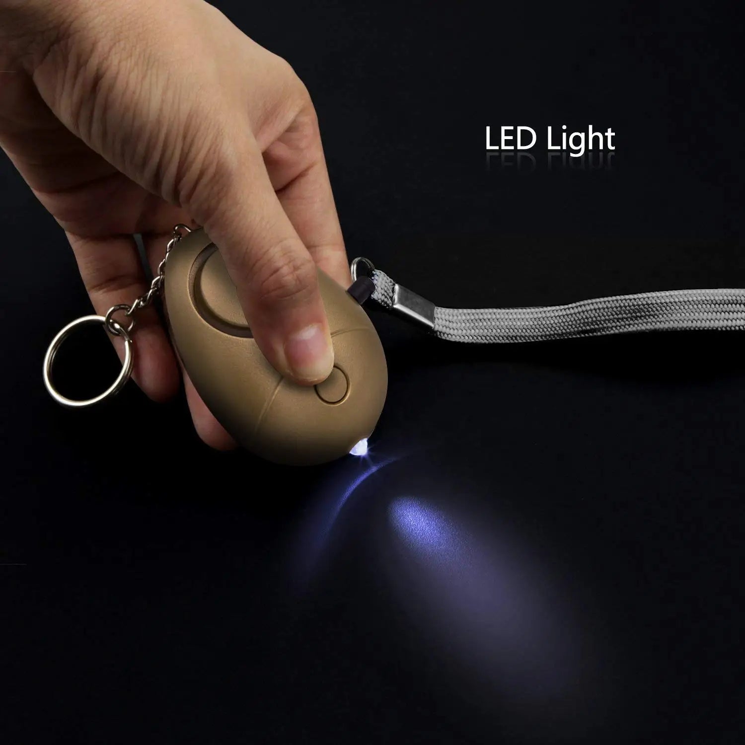 Tan-colored oval-shaped security alarm keychain with LED flashlight, silver metal ring, and lanyard for convenient carrying.