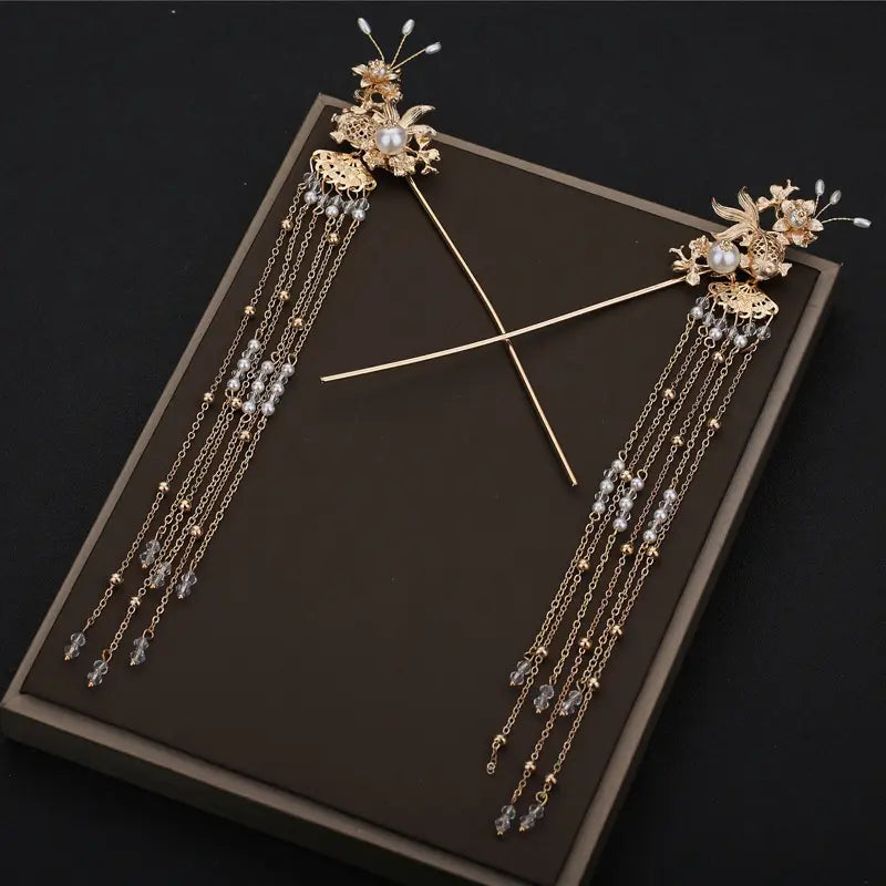 Elegant chinese bridal jewelry gold-colored ornate hairpins with intricate floral designs pearl accents and cascading chains of beads and crystals.