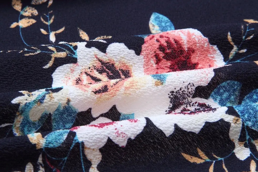 dark navy boho style long dress women featuring a vibrant floral pattern with large white pink and blue blossoms and gold toned leaves in an off shoulder maxi design