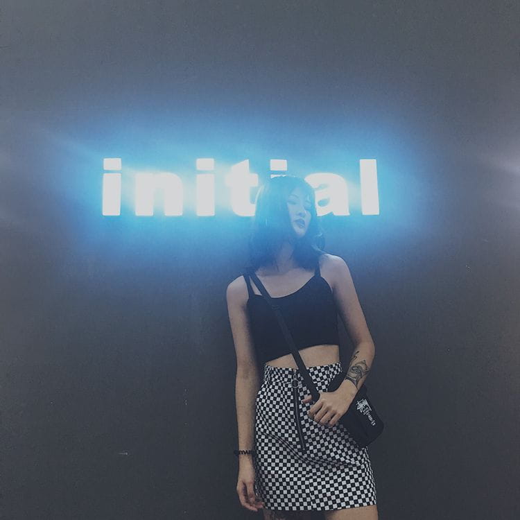 black crossbody bag with white logo paired with checkered mini skirt featuring variable mso-font-signature pattern in monochrome tones