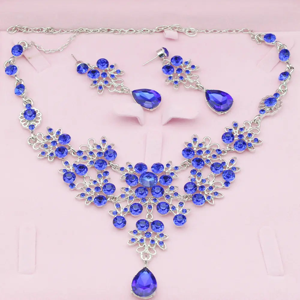 a sparkling royal blue crystal butterfly big water drop necklace and earring set featuring silver-toned floral designs and teardrop pendants