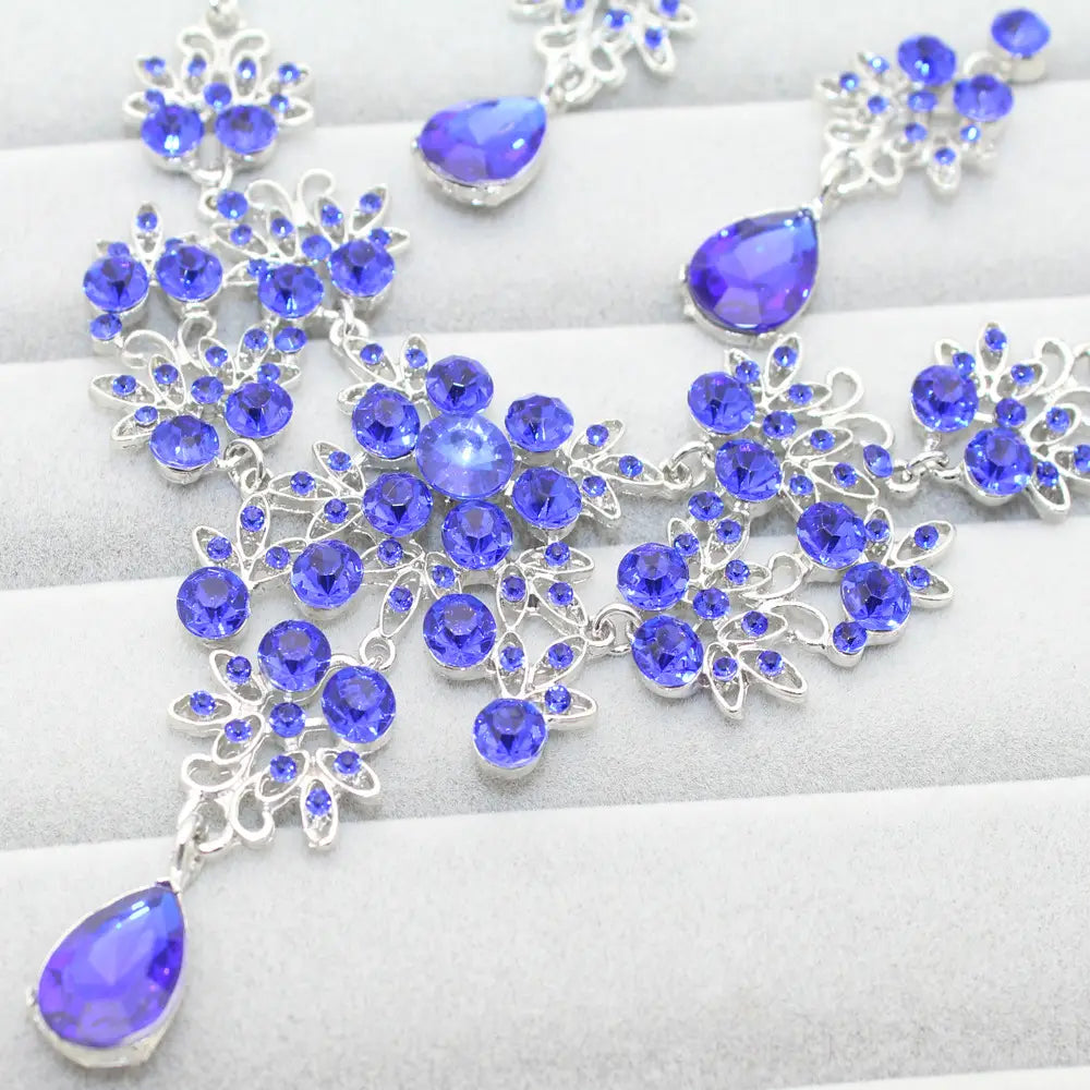 A sparkling royal blue crystal butterfly big water drop necklace with intricate silver filigree design and dangling teardrop pendants in an elegant earring set.