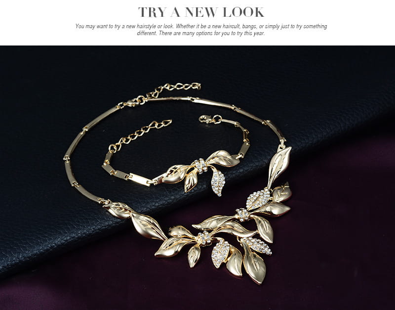 gold-toned leaf-themed necklace and matching bracelet bridal wedding jewelry set adorned with sparkling rhinestones for bridal wedding use.