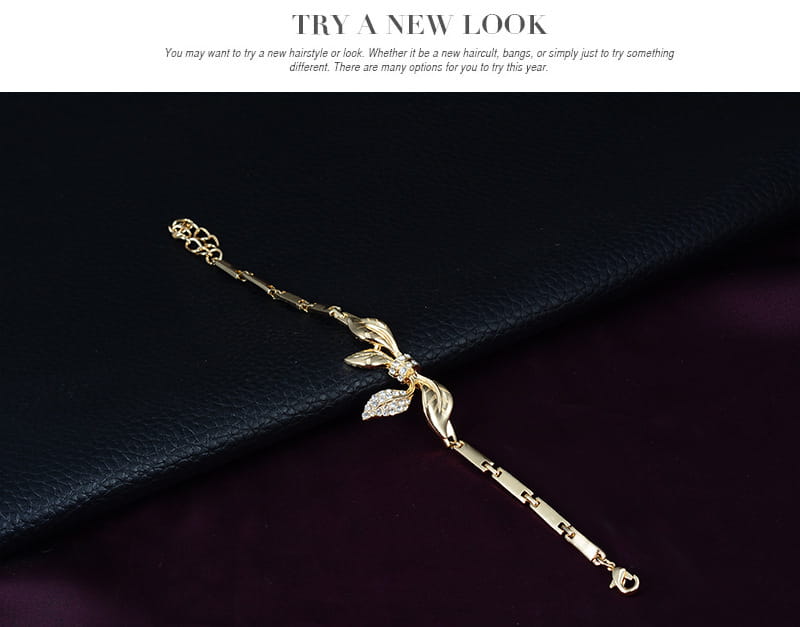 gold-toned bracelet with an intricate leaf and diamond-encrusted center design featuring a sleek chain link structure from a bridal wedding jewelry set.