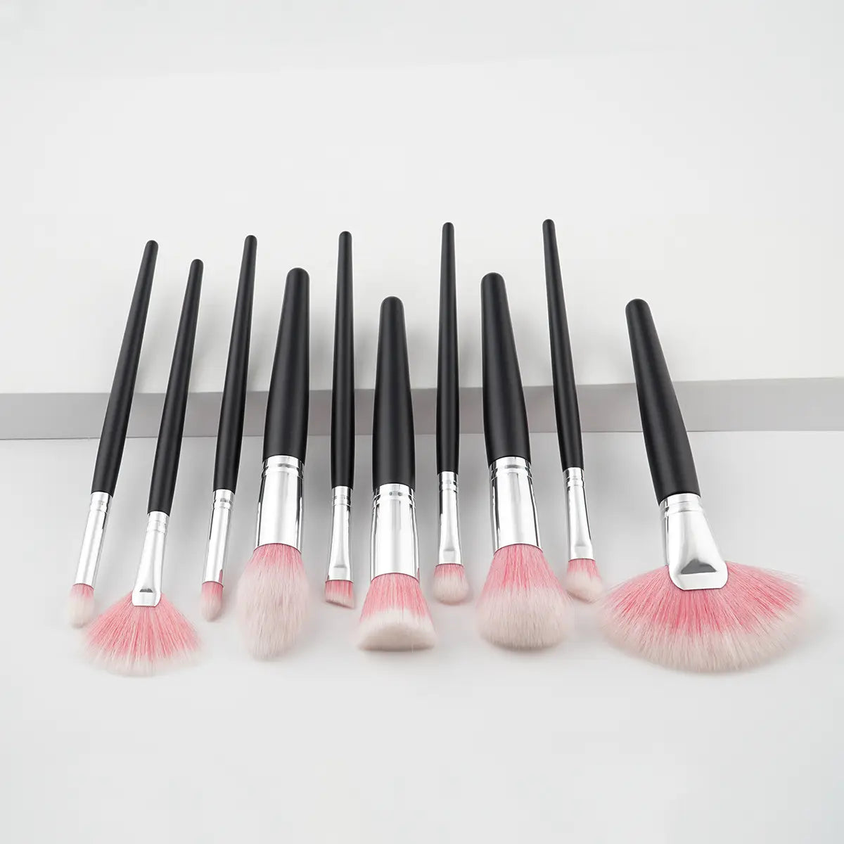10 piece purple gradient makeup brush set with ten pink and white gradient synthetic bristle brushes featuring black handles and silver ferrules.