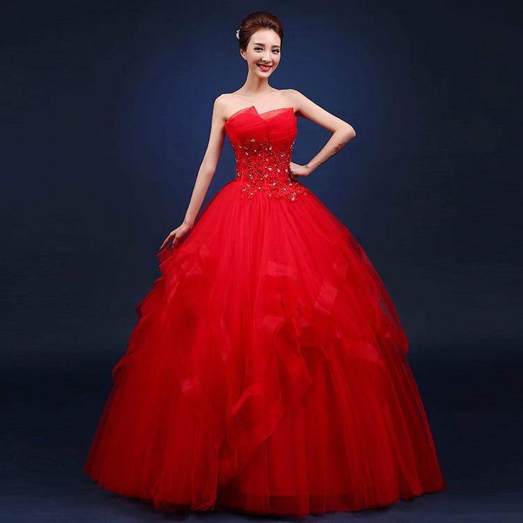 A vibrant red strapless ball gown wedding dress with a beaded bodice and layered tulle skirt designed to complement neatly slim one-shoulder wedding dresses.