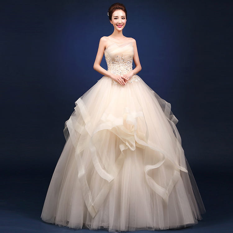 beige strapless wedding gown with intricate beading and layered tulle skirt complementing neatly slim wedding dresses and one-shoulder wedding dresses styles