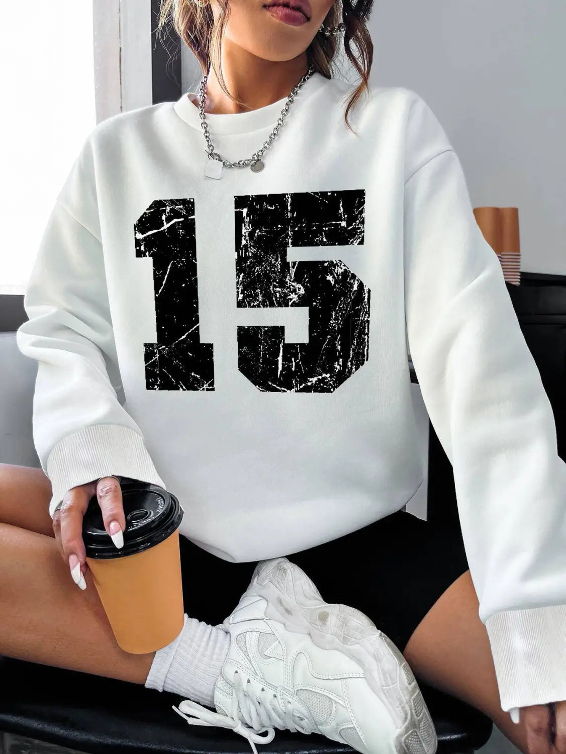 White crew neck sweatshirt featuring a black distressed number 15 printed across the chest.