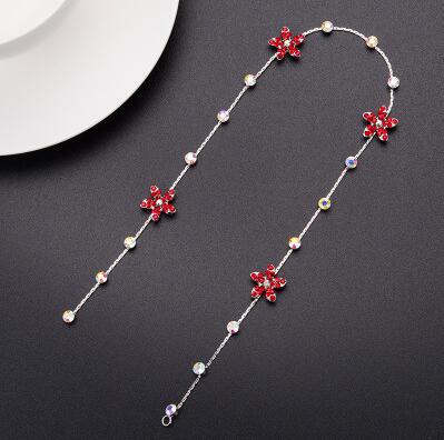 A delicate silver chain wedding hair accessory adorned with vibrant red floral charms and sparkling clear crystals for elegant wedding hair.