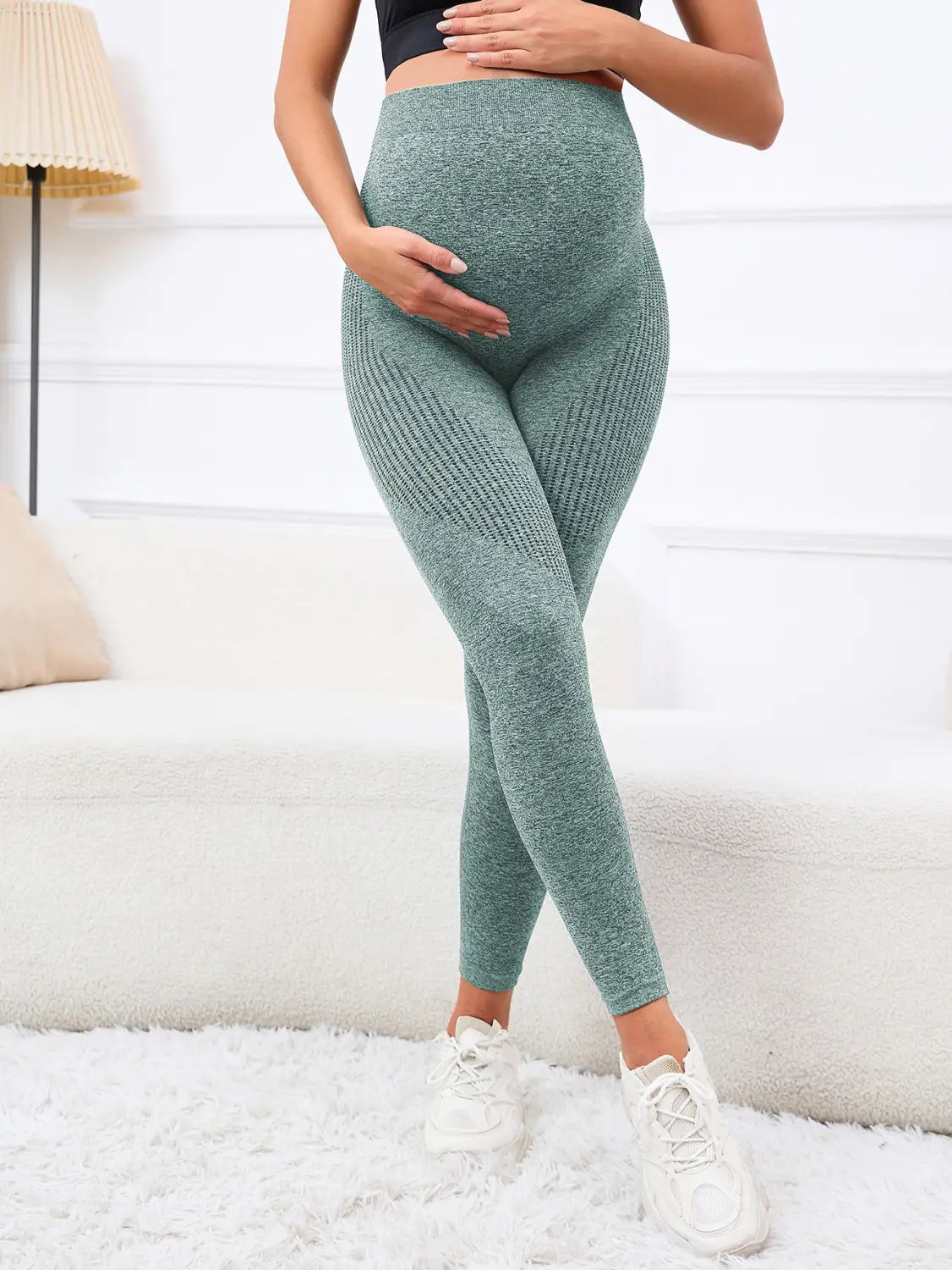 a pair of high-waisted ribbed green maternity leggings made of textured knit fabric featuring support high waist belly support.