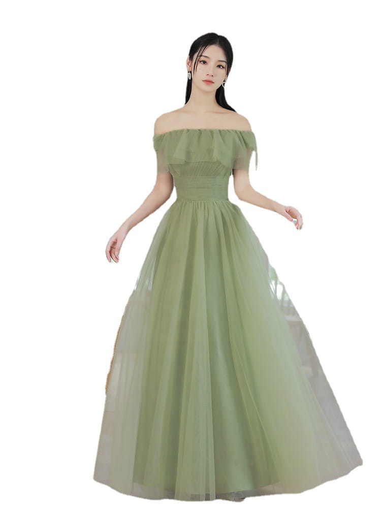 A flowing fruit green type fashion personalized long tulle dress with an off-the-shoulder ruffled neckline and fitted bodice.