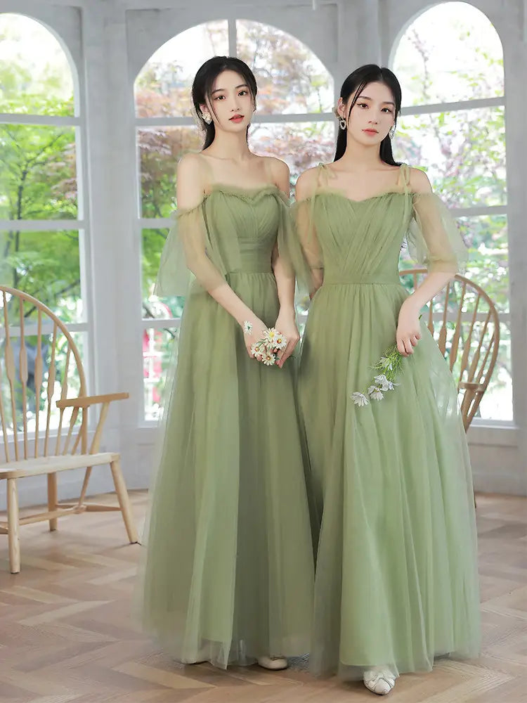 two identical fruit green type fashion personalized long off-the-shoulder dresses made of sheer tulle with delicate floral embroidery on the skirt.