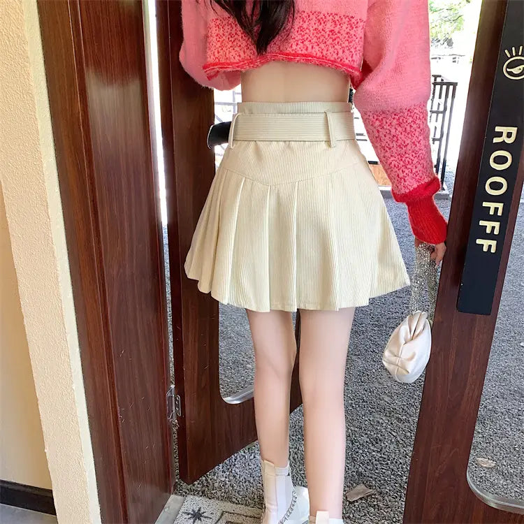 beige pleated corduroy half skirt with a matching brown belt featuring a skirt pleated design in a mini length