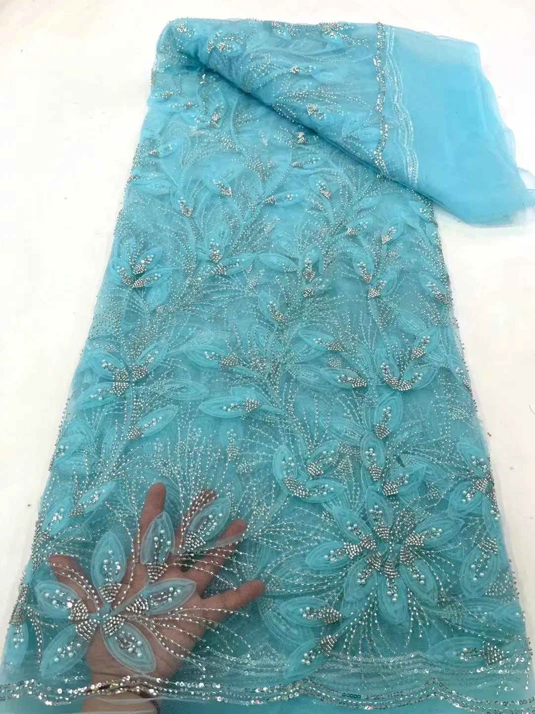 a delicate turquoise peach ribbon flower beaded tulle lace fabric featuring intricate silver beading and floral embroidery