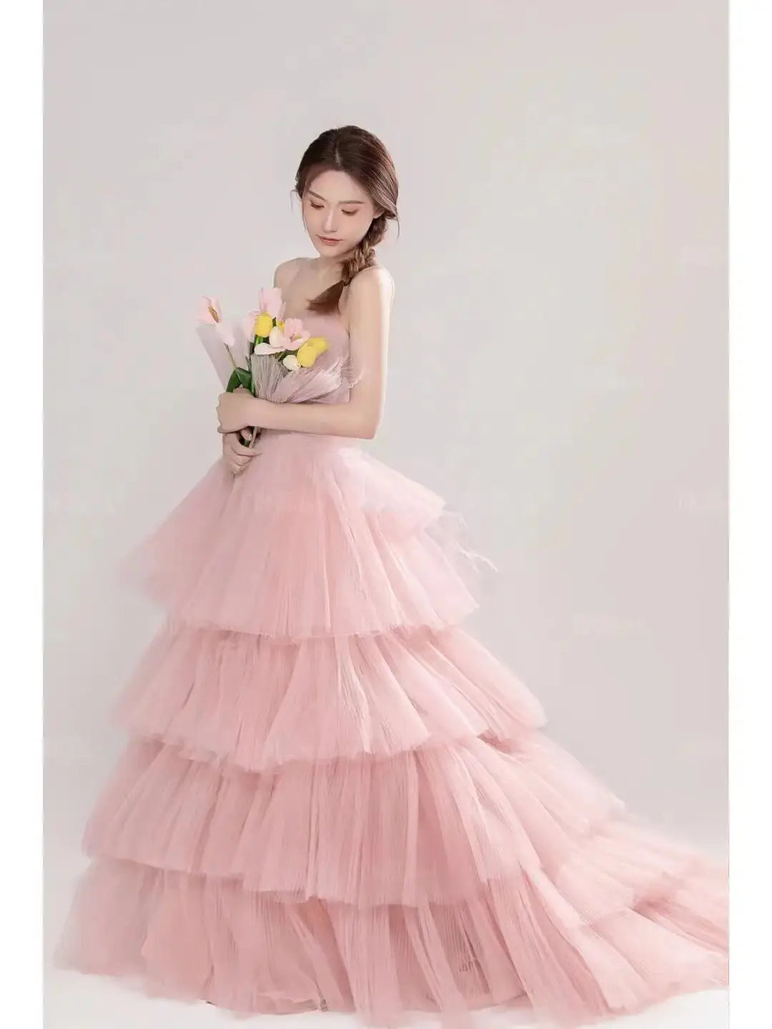 a soft pink multi-tiered tulle wedding photography dress with a strapless bodice and flowing skirt perfect as a photography dress pink or dress pink white option