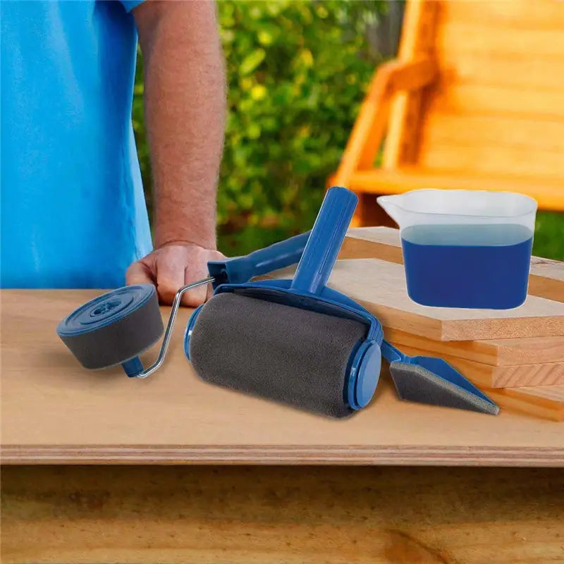 Seamless sponge corner paint brush roller with a blue handle, gray foam roller head, metal frame, and matching blue paint tray for precise corner paint application.