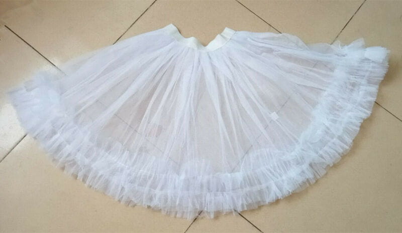 white multi-layered tulle petticoat with a flared ruffled silhouette as main fabric component of a women christmas dress sexy velvet christmas dress with fur trim