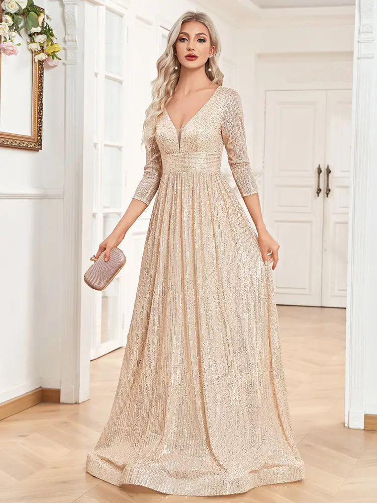 A shimmering champagne-colored sequined evening gown with a deep v-neckline and three-quarter length sleeves designed as a high waist party formal dress.