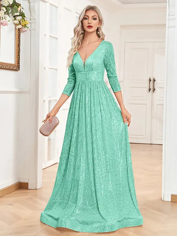 A shimmering mint green sequined evening gown with a deep v-neckline and three-quarter length sleeves designed as a high waist party formal dress.