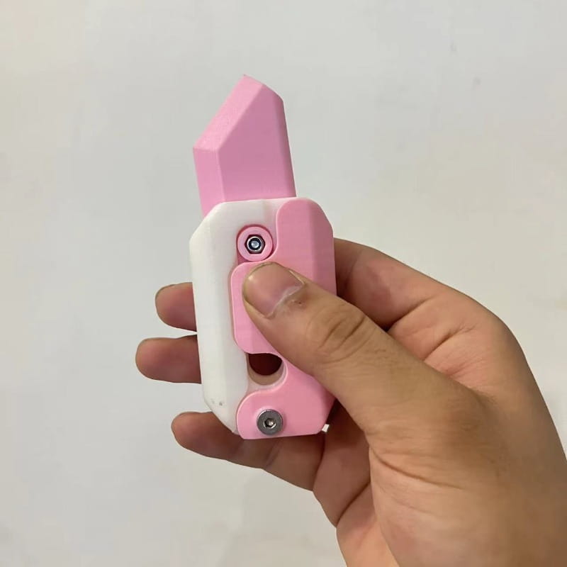 Pink and white plastic radish knife toy with a pointed blade for gravity cub jumping and printing gravity cub play.