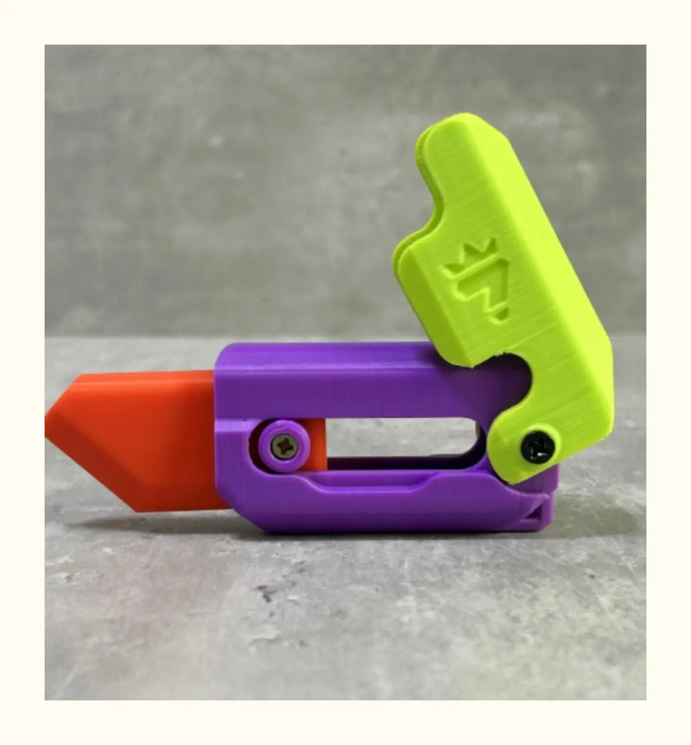A vibrant purple, lime green, and orange plastic radish knife toy cutter featuring a crown logo on the handle, designed as a printing gravity cub for gravity cub jumping play.