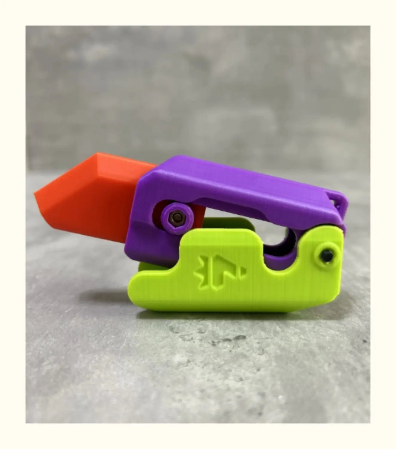 vibrant multi-colored plastic pipe cutter with orange purple and lime green sections designed for use with the pink and lime radish knife gravity cub toy featuring printing gravity cub and gravity cub jumping functionalities.