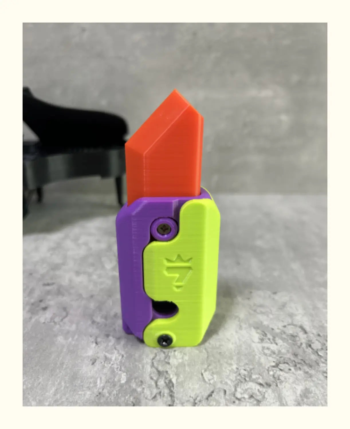 vibrant orange and purple-green plastic radish knife multi-tool designed to resemble a lipstick for the pink and lime radish knife printing gravity cub toy.