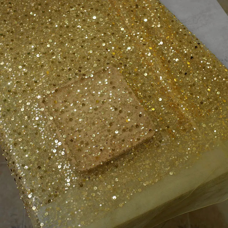 a shimmering gold sequined pearl embroidery lace fabric with a square translucent patch featured in a sequined pearl embroidery lace asymmetric dress