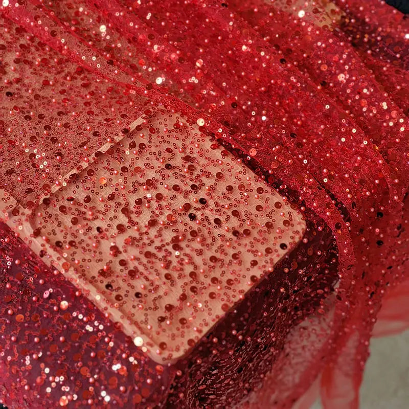 a shimmering red sequined pearl embroidery lace asymmetric dress with sheer flowing fabric and scattered glittery embellishments