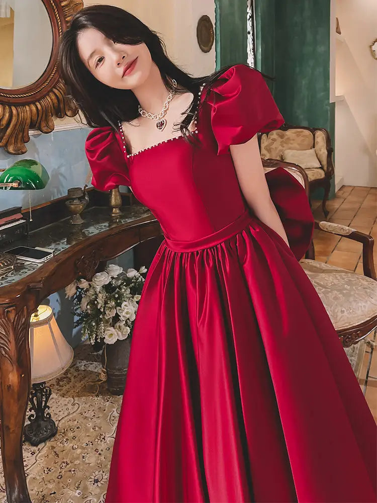 a rich winter wine red satin ball gown engagement dress with puffed short sleeves and a square neckline