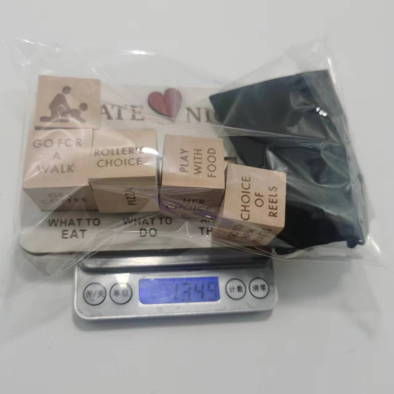 Set of light brown wooden cubes with engraved text and heart design packaged in clear plastic for the wooden date night dice game board.