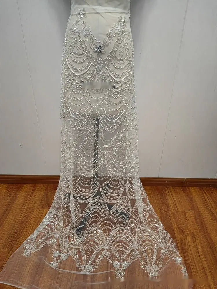 a sheer white lace skirt from the wave style sequin bead lace fabric wedding dress featuring intricate silver beading and sequins in a cascading scalloped pattern