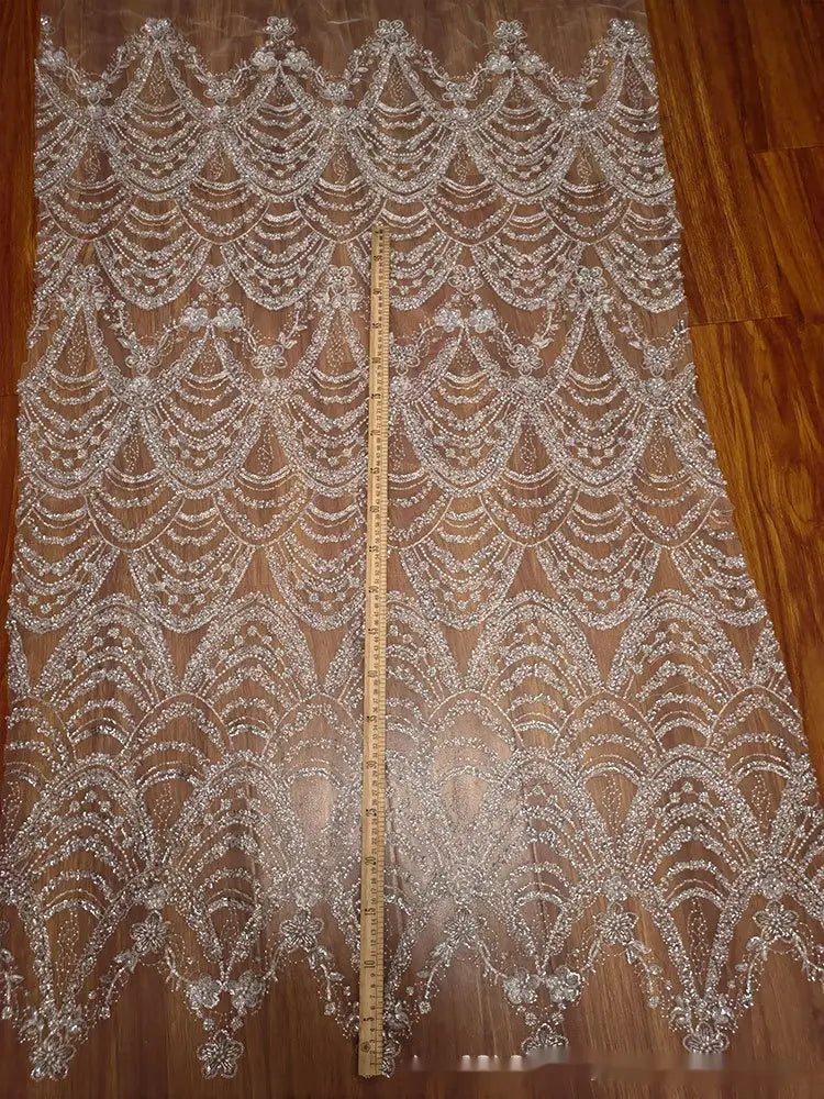 a sheer silver-beaded lace fabric with intricate scalloped and floral patterns featuring wave style sequin bead design for wedding dress use