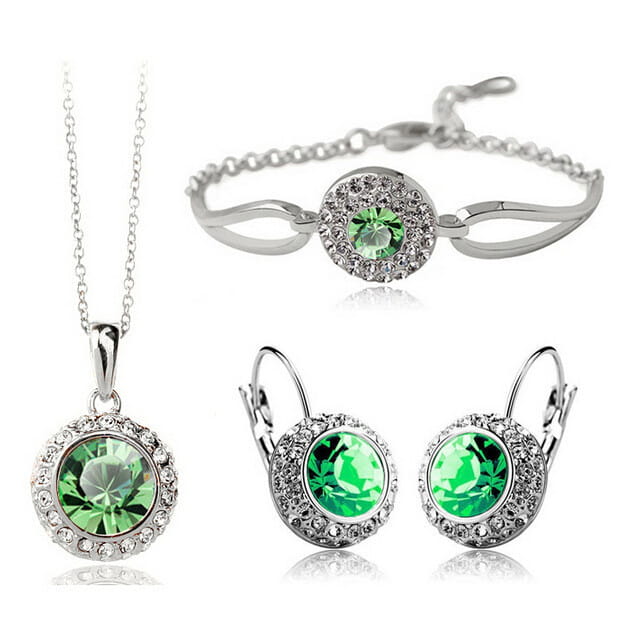 silver-toned korean style jewelry set featuring a central fruit green crystal surrounded by smaller clear crystals in each piece.