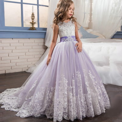 A young girl wears a lavender tulle lace wedding dress for children with intricate white lace detailing and a beaded bodice suitable for clothing lace wedding events in the United States.