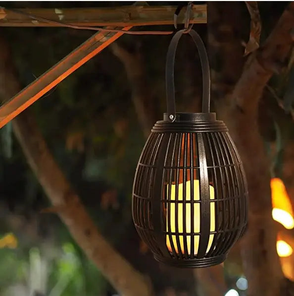 black woven rattan lantern with a warm yellow light glowing inside designed for solar retro patio and explosive solar retro use