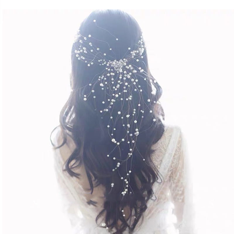 Delicate silver beaded bridal headdress handmade with cascading tiny white pearls and fine wire framing the back of a woman’s head, showcasing the handmade pearl fairy design.