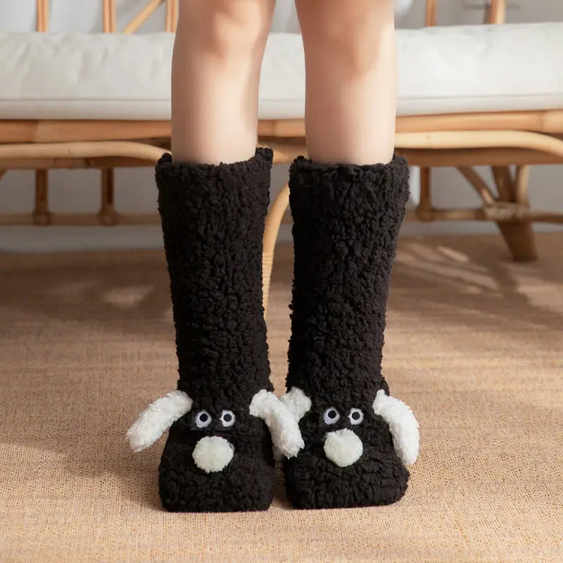 Cute cartoon dog floor socks made of black fluffy material with white ears and nose details designed as boot socks for indoor use.