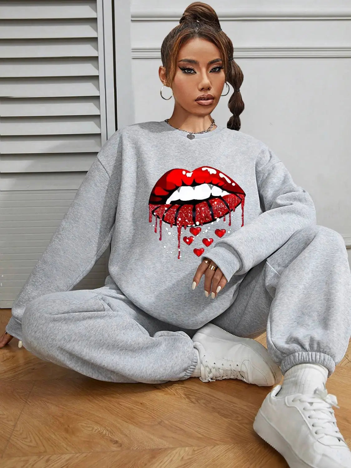 gray pocketed long sleeve sweatshirt featuring a bold red glittery lips graphic dripping down and surrounded by small hearts
