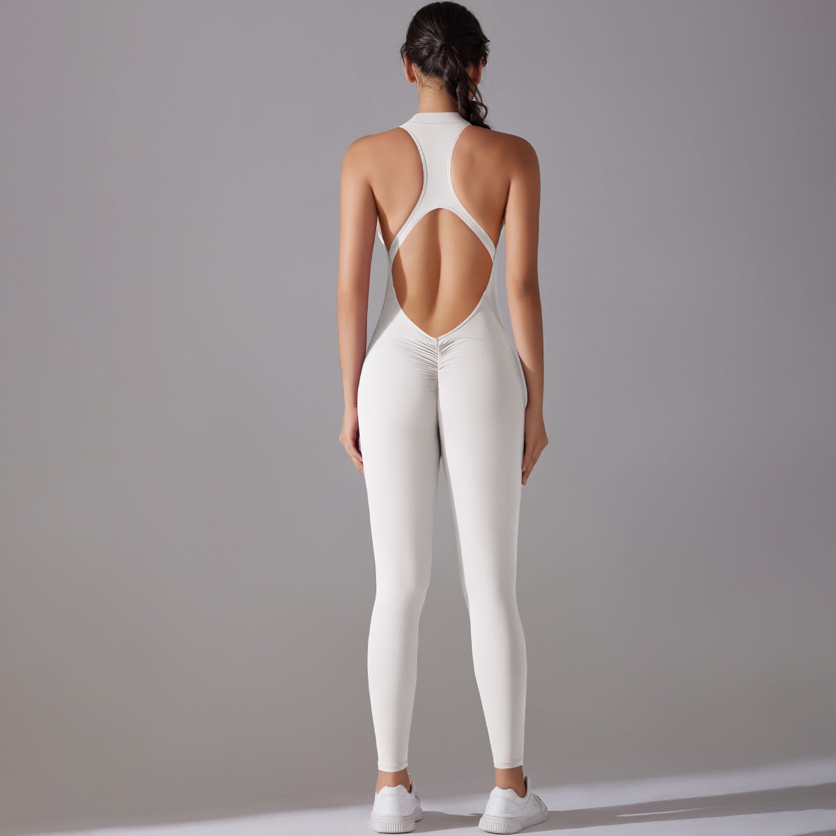 white form-fitting one-piece long pants jumpsuit yoga fitness slim bodysuit with a high neckline and open back design shown from the back side
