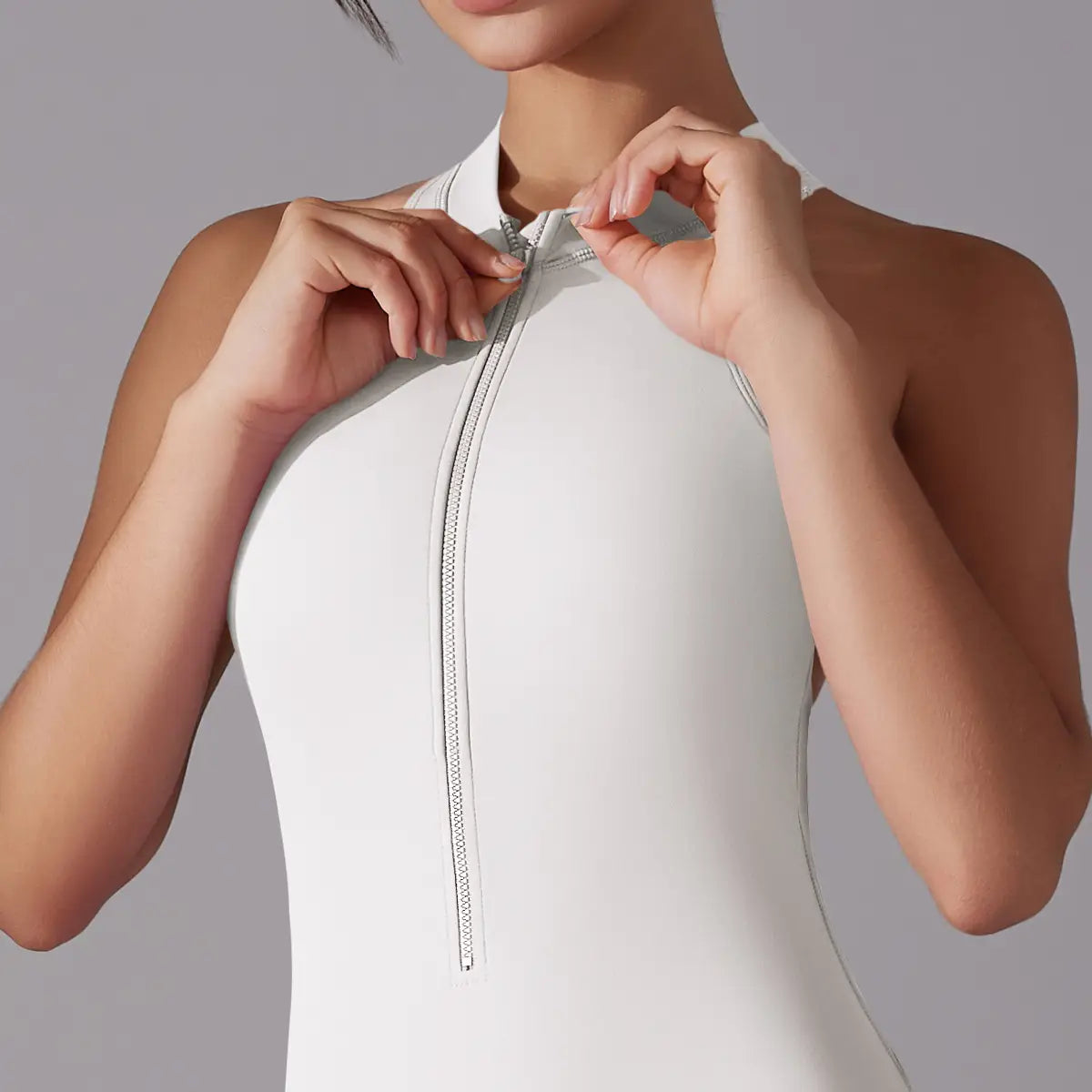 A sleek white high-neck athletic one-piece with a silver zipper in a light blue long pants jumpsuit designed for jumpsuit yoga fitness and slim bodysuit use.