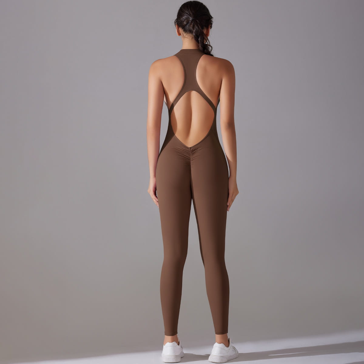 a sleek solid brown long pants jumpsuit yoga fitness slim bodysuit shown from the back featuring a distinctive open-back design with crisscross straps