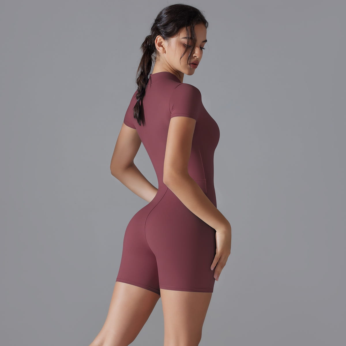 A form-fitting maroon seamless short-sleeved shorts jumpsuit yoga bodysuit with a high neckline and summer zipper for women.
