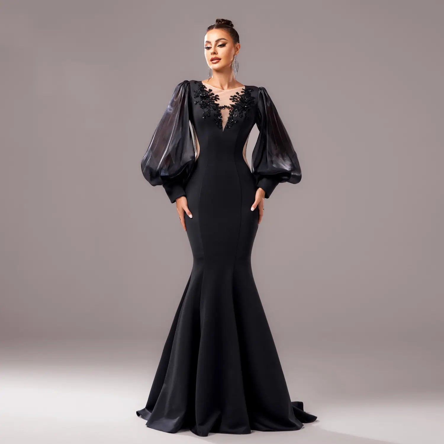Elegant black long sleeve round neck fishtail gown featuring sheer puffy sleeves and intricate floral embroidery at the neckline.