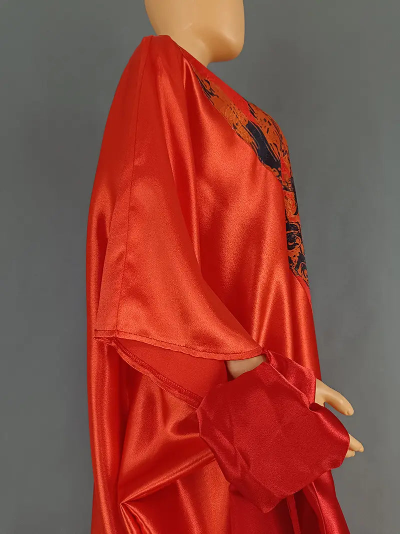 Vibrant red satin robe with black floral embroidery along the shoulder and sleeve.