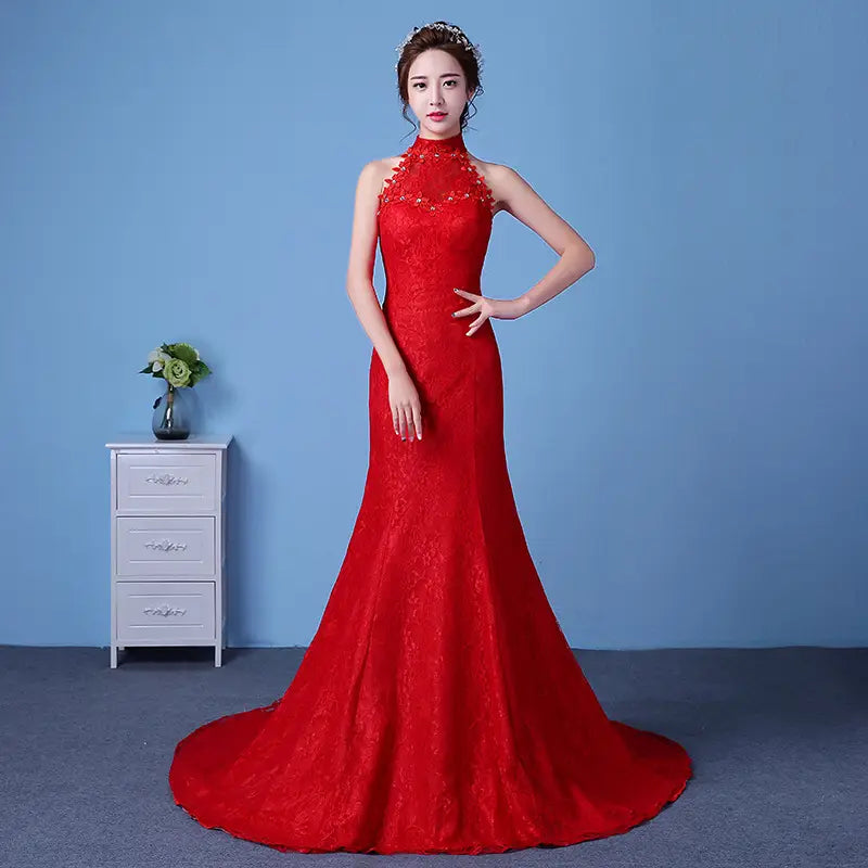 A vibrant red lace mermaid style wedding dress with a high neckline and intricate floral embroidery designed for a big red wedding and flattering size waist.