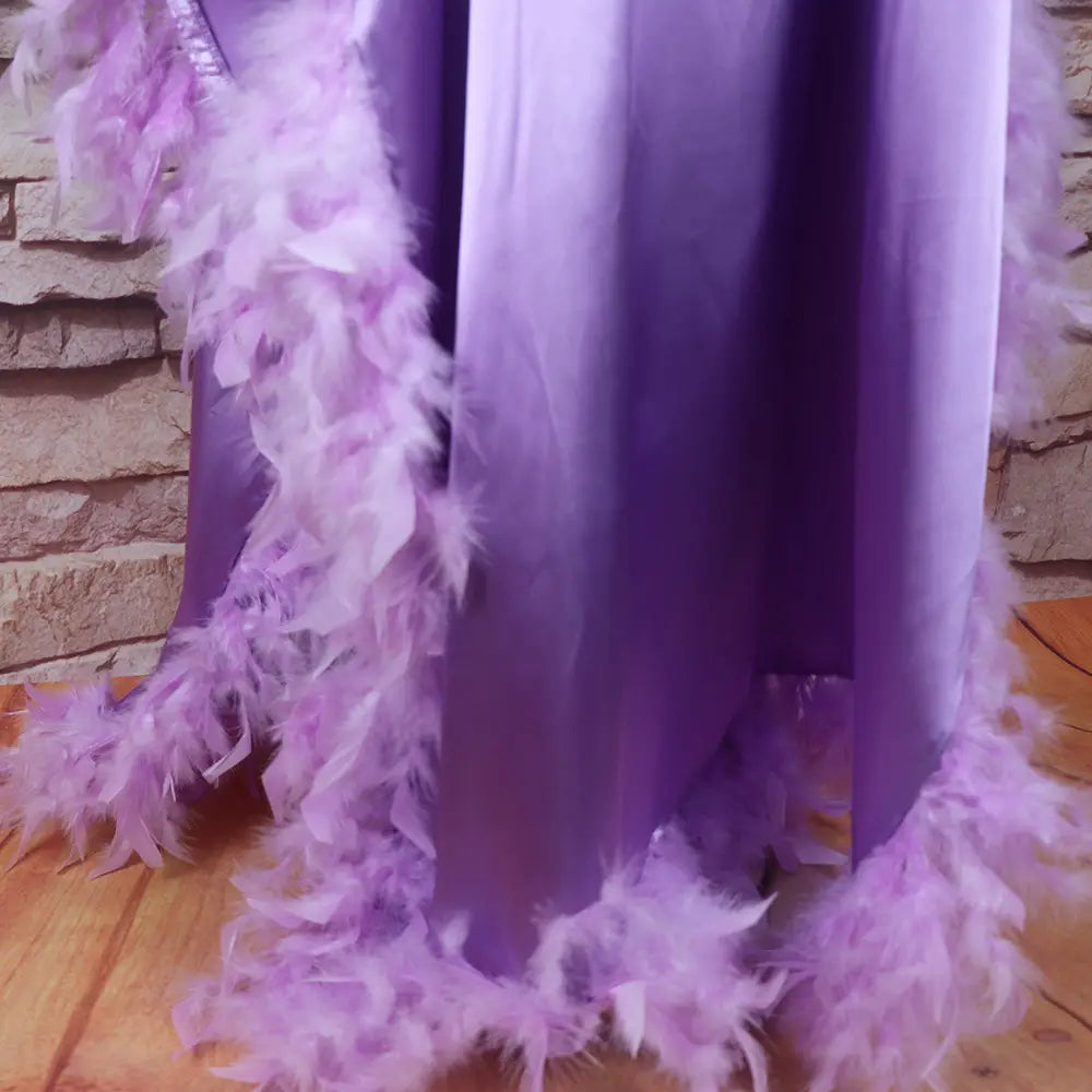 a flowing lavender satin loose dress luxury robe fully adorned with a matching orange feathered boa luxury fully surrounded