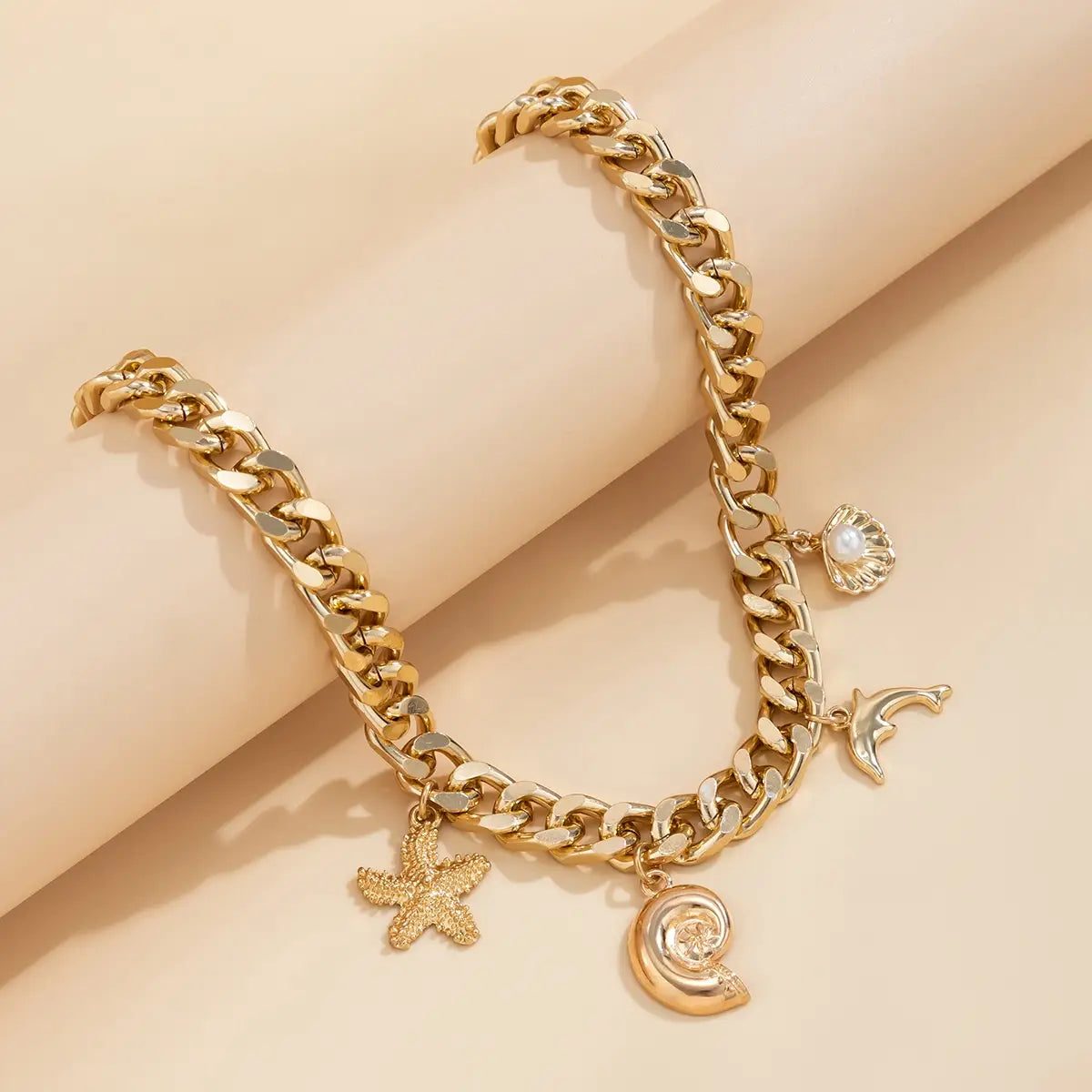 Gold-toned chunky chain bracelet set featuring sea-themed charms including starfish conch dolphin seashell and pearl from the boho conch dolphin starfish choker necklace bracelet set.