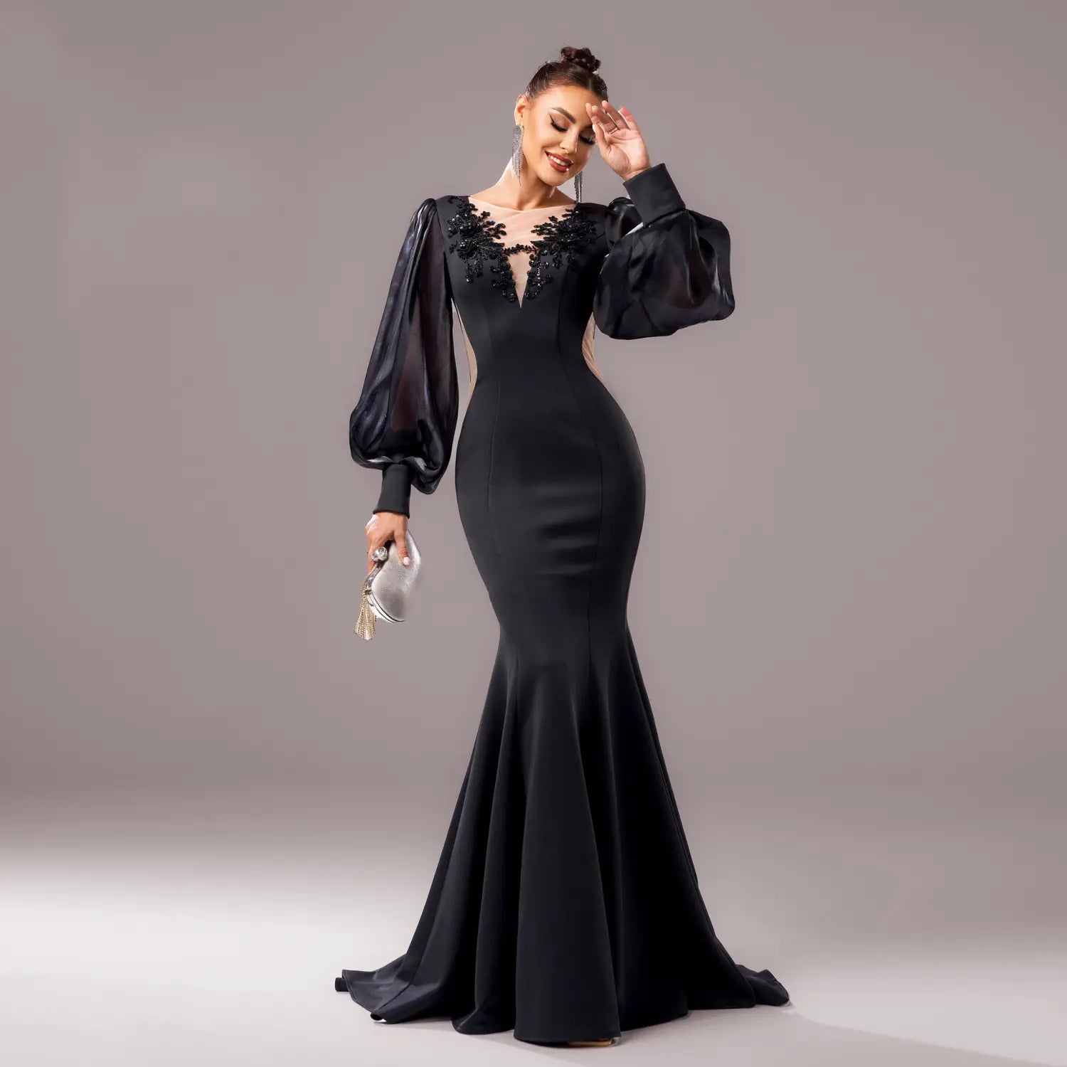 Elegant black long sleeve round neck fishtail gown featuring sheer puff sleeves and intricate floral embroidery at the neckline.