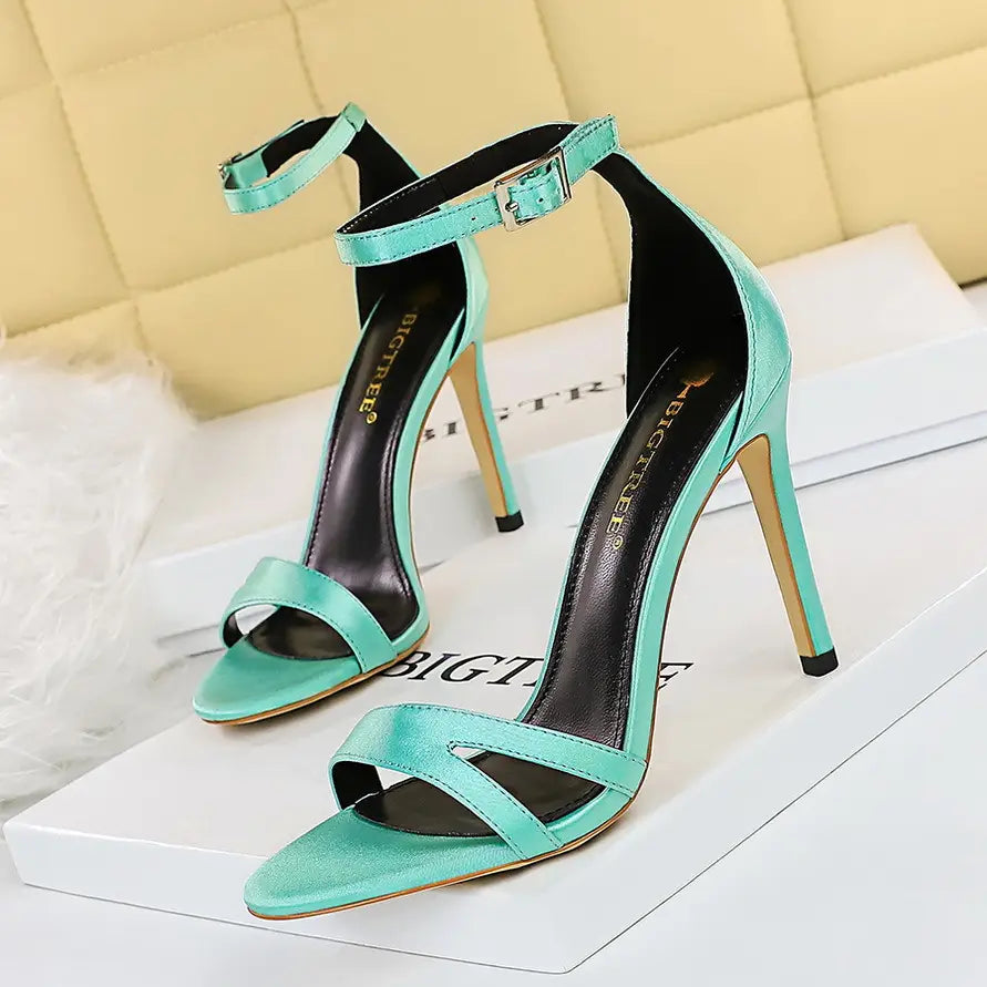 a pair of mint green satin high heel toe sandals with a sleek open-toe design and ankle straps in a black satin high heel toe cutout sandal style